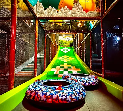 Two padded donut tubes at the top of the green Donut Slide runway