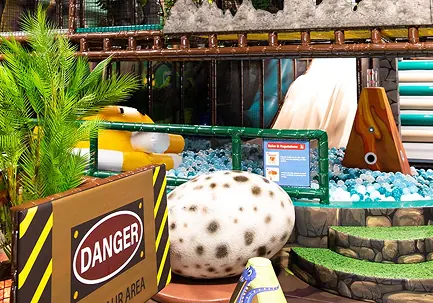 The jungle-themed Jurassic Soft Play area with a giant speckled dinosaur egg, ball pit and climbing frame behind it